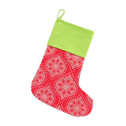 Red Christmas stocking with white holiday motifs and green cuff on white