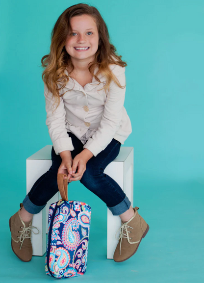 Child seated with a colorful patterned cosmetic pouch